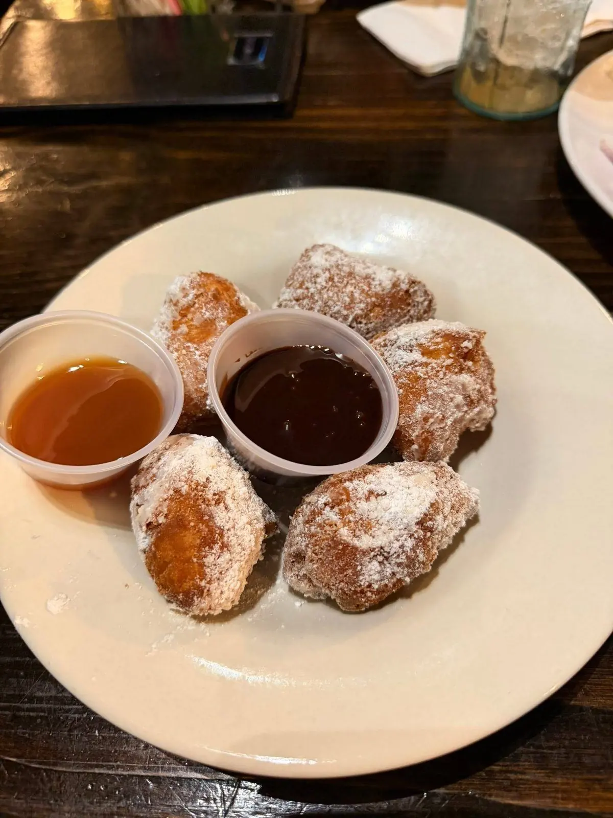 Powdered-sugar beignets with caramel and chocolate dipping sauces